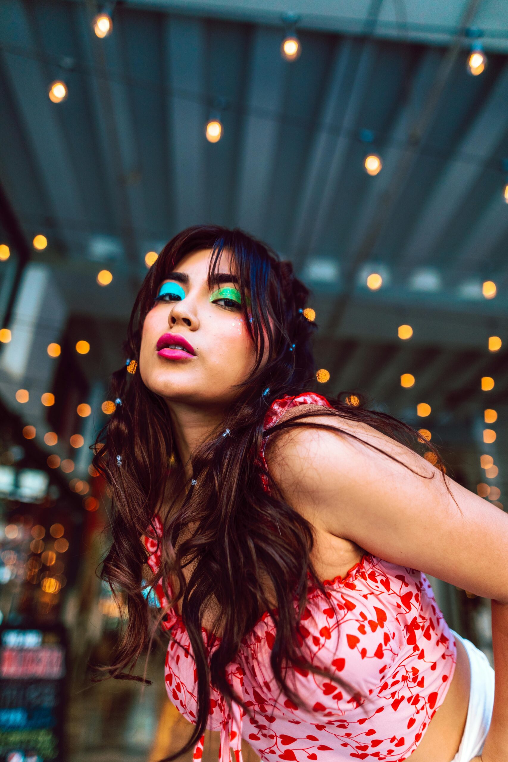 Woman with vibrant makeup and colorful lights.