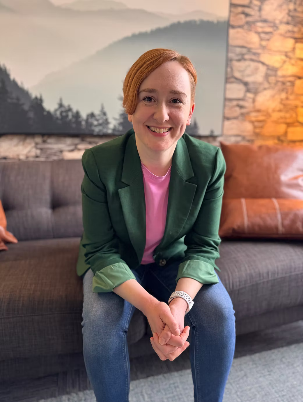 Smiling person sitting on a gray couch