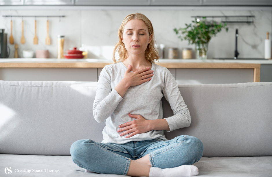 Woman meditating on couch in peaceful home setting.