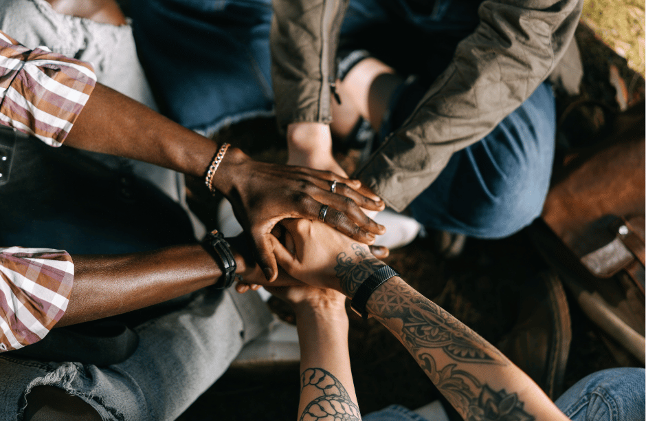 Diverse hands stacked in a unity circle